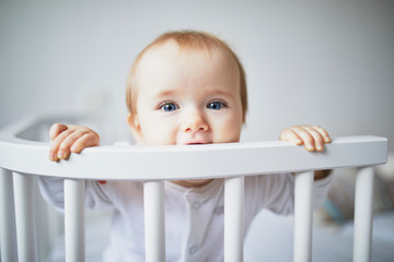 Adorable baby girl in co-sleeper crib