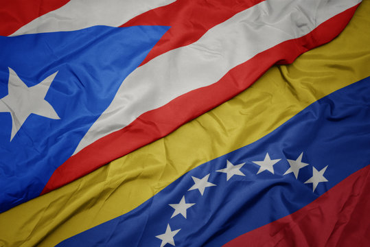 waving colorful flag of venezuela and national flag of puerto rico.