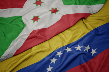 waving colorful flag of venezuela and national flag of burundi .