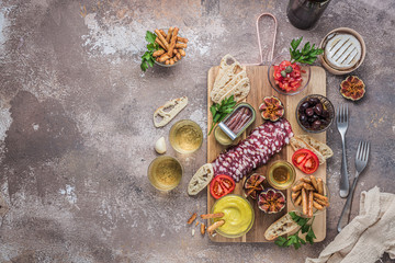 Typical spanish tapas concept. Salami, cheese, bowls with olives, tomatoes and alioli dip. Copyspace