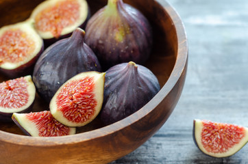 Ripe fig fruits are in the wooden bowl