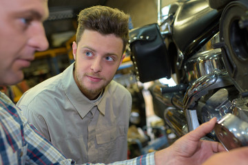 two mechanics in a motorbike garage