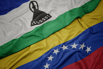 waving colorful flag of venezuela and national flag of lesotho.