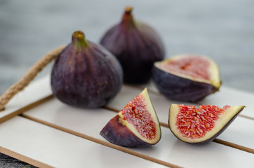 Ripe fig fruits are on the white wood.