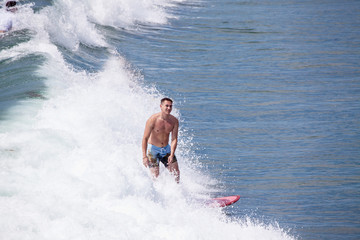 Naklejka premium surfer iding the waves at pacific beach