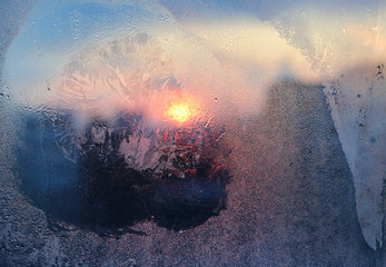 Ice pattern and water drops on glass on a sunny winter morning