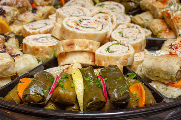 Mediterranean filo dough specialties, including chicken cilicia, dolmas, and Levant sandwiches on a platter as seen from above. 