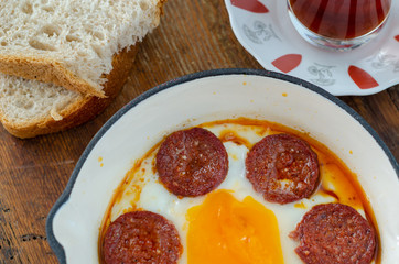 Turkish breakfast with fried egg,  sucuk and Turkish tea