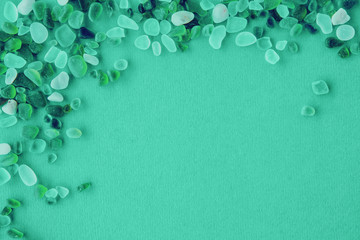 Close up of various sea glass pieces on trendy mint background. Design template. Corner frame with...