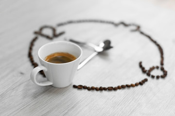 Coffee beans folded in the form of a clock. Instead of the number 9, a cup of coffee, which means...