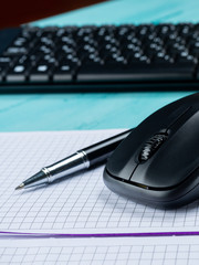 Office table desk. Workspace with blank note book, keyboard, office supplies, on wooden background.