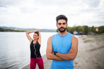 fit couple on beach exercising