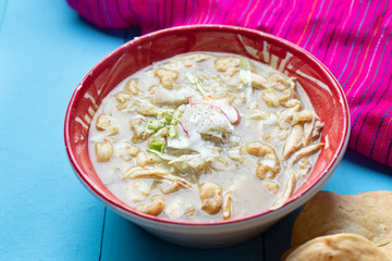 Mexican green pozole soup on blue background
