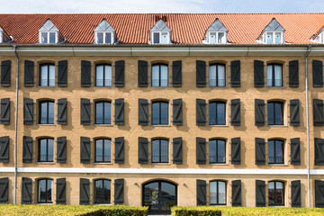 Obraz premium Pattern formed by multiple open windows with shutters in a large residential building on a sunny day