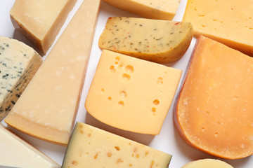 Composition with different kinds of tasty cheese on white background, top view