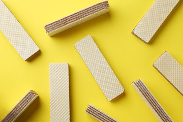 Tasty wafer sticks on yellow background, flat lay. Sweet food - obrazy, fototapety, plakaty