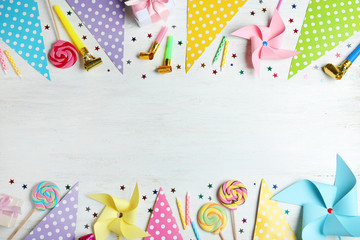 Colorful birthday accessories on white wooden background, flat lay. Space for text