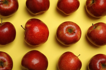 Flat lay composition with ripe juicy red apples on yellow background