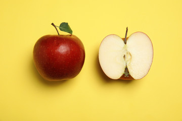 Flat lay composition with ripe juicy red apples on yellow background