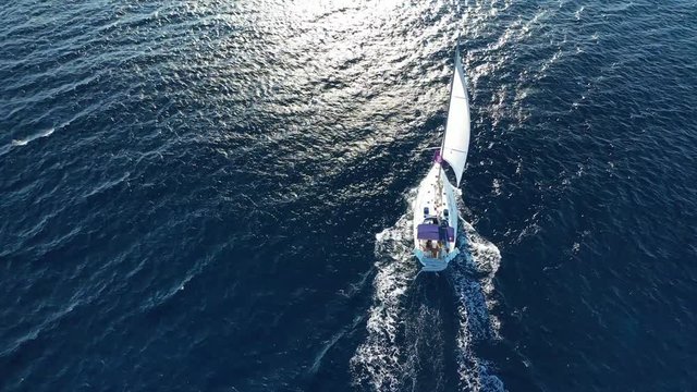 Aerial drone tracking video of beautiful sail boat cruising in the deep blue Aegean sea, Greece