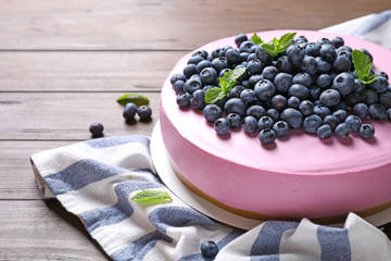 Tasty blueberry cake and napkin on wooden table. Space for text