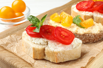 Fototapeta na wymiar Tasty fresh tomato bruschettas on wooden board, closeup