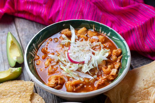 Mexican red pozole soup on wooden background