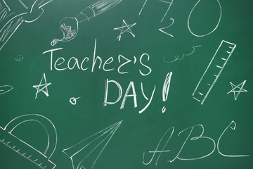 Green chalkboard with inscription TEACHER'S DAY and drawn stationery