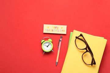 Flat lay composition of card with inscription HAPPY TEACHER'S DAY and stationery on red background, space for text