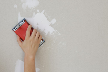 Process of sanding wall with a sanding block after skim coating. Preparation before painting....