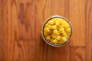 uncooked pasta in a mason jar on wood surface