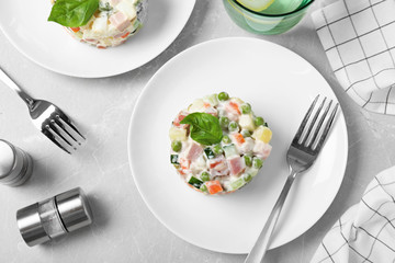 Delicious salad Olivier on light table, flat lay
