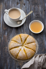 Freshly baked carrot scones with honey and cup of tea with milk on wooden background. delicious homemade cakes