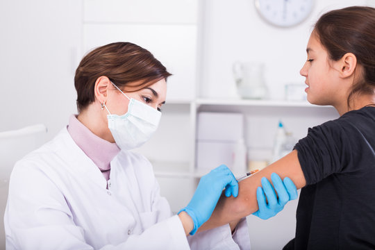 Nurse in mask making injection