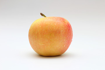 Isolated single yellow-orange-red apple on white background. Studio macro shoot