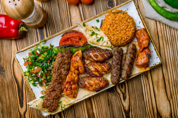 assorted kebabs with bulgur and vegetables Turkish cuisine on wooden table