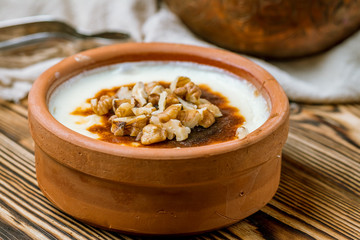 sutlac with nuts on wooden table. Turkish cuisine.