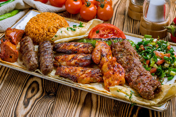 assorted kebabs with bulgur and vegetables Turkish cuisine on wooden table
