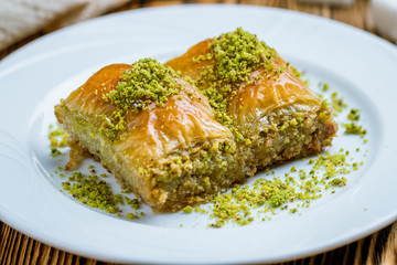 baklava durum with pistachios on wooden table. Turkish cuisine
