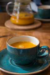 Close up of healthy tes infusion in a tea cup on wooden table