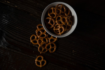 Pretzels in a bowl on a dark wood table