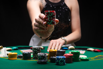 Girl plays poker and raises bets with chips. Horizontal frame in a night game club. Casino Concept, Player, Winner. Gaming Business