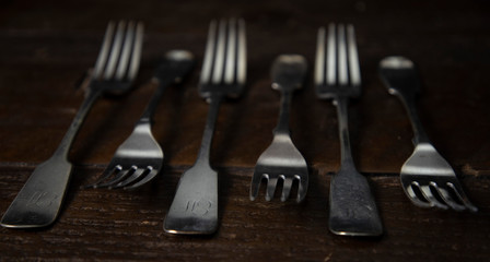 Vintage silver forks arranged on a dark wooden table