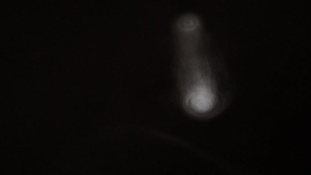Vortex ring from vape smoke moving towards right in a black background, slow motion isolated