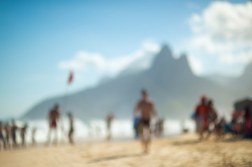 Obraz na płótnie Canvas Abstract defocus view of a busy day on Ipanema Beach in Rio de Janeiro, Brazil with the looming silhouette of Two Brothers Mountain