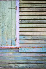 Old wooden slats with weathered pastel paint fading away in a full frame background