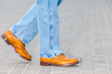 Close-up of Male Legs In Leather Brown Oxford Semi Brogues Shoes. Photographed in Motion While...