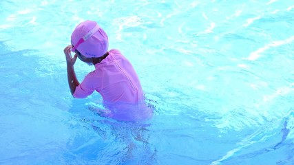 4K : Asian kid girl practice diving and swimming in swimming pool., Kid learning swimming concept.