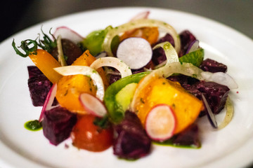 Plate of colorful spring salad prepared by a man chef 