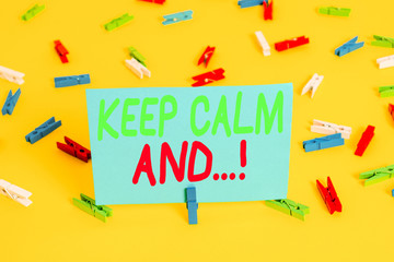 Writing note showing Keep Calm And. Business concept for motivational poster produced by British government Colored clothespin papers empty reminder yellow floor background office